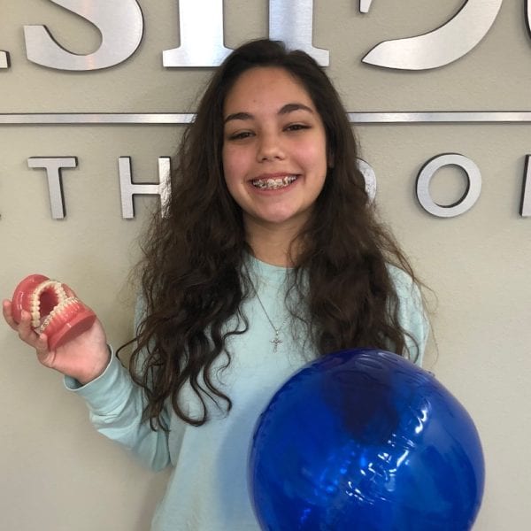 Jocelyne, EmBraces Anti-Bullying Ambassador of Fishbein Foundation, young girl smiling in front of Fishbein Orthodontics office, free orthodontic treatment