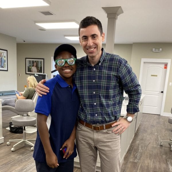 Davy, EmBraces winner, Dr. Ben Fishbein standing beside Davy, smiling, free orthodontic treatment, Fishbein Orthodontics